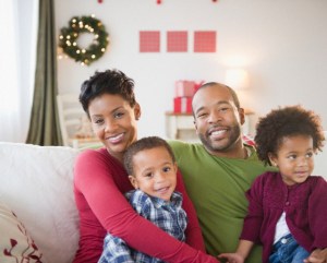 Black family relaxing on sofa together